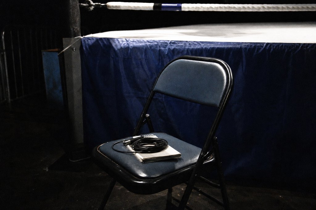 Ein leerer Presseplatz am Ring zwischen den Runden mit einem geschlossenen Notizbuch auf dem Stuhl