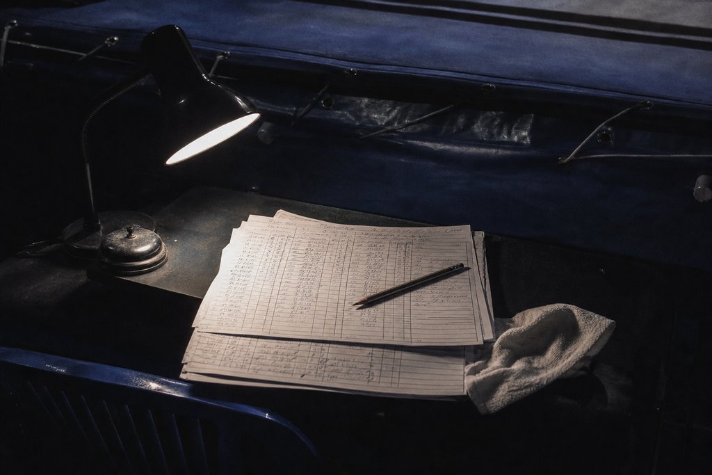 Der Tisch der Punktrichter am Ring mit gestapelten Wertungskarten unter einer Lampe